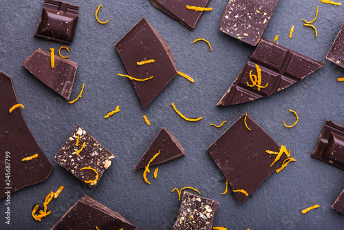 Принти на полотні Dark chocolate slices with orange zest pattern, top view