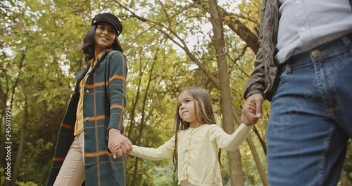 Happy asian parents and their little daughterwalking together in golden fall garden, enjoying theit time - young family concept 4k photo