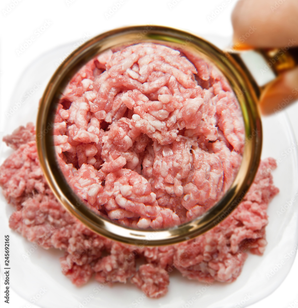 Minced red meat with a magnifying glass. We study the composition of products. Minced red meat with a magnifying glass. We study the composition of products.
