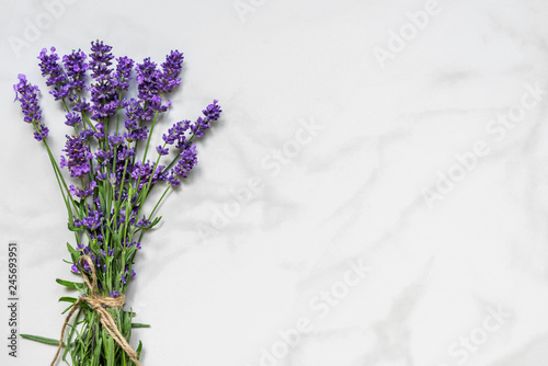 Fototapeta Naklejka Na Ścianę i Meble -  Beautiful lavender flowers bouquet on white marble table with copy space for your text. top view. flat lay