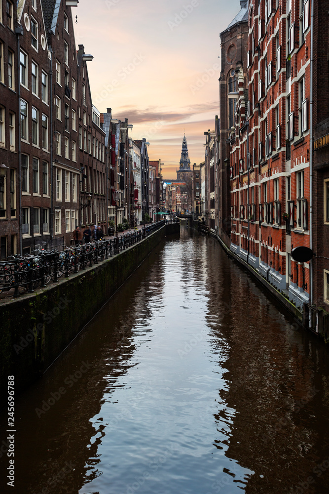Amsterdam canal view bordered by bricks residence and housing are during the sunset, Amsterdam, Netherlands