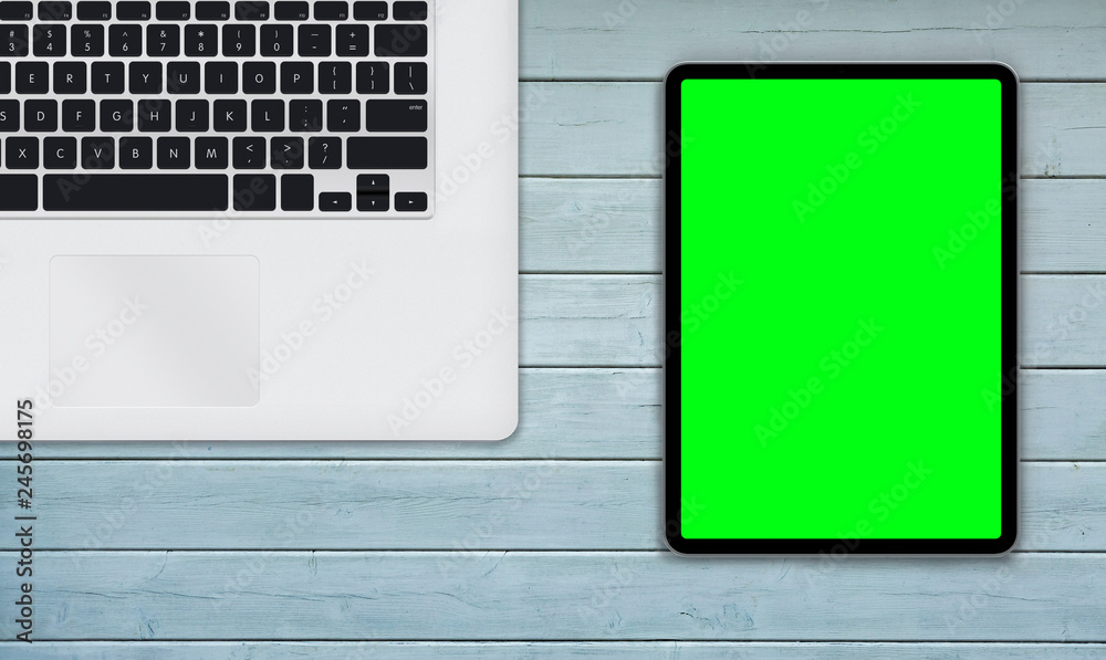Top view of digital tablet and computer with green isolated screen on wooden desk. Concept workplace. Top view of digital tablet and computer with green isolated screen on wooden desk. Concept workplace.