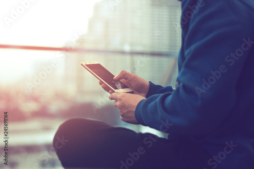 man with social mobile phone for connect to network internet technology with town city background