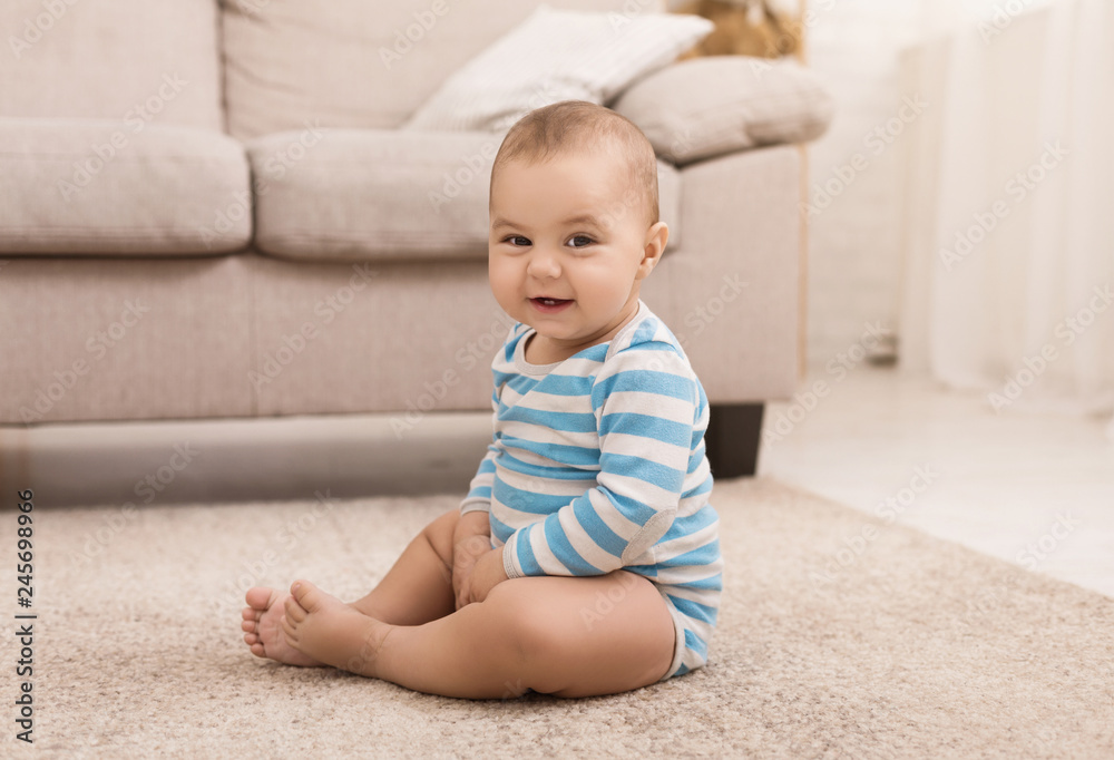 Cute baby boy sitting on floor at home Cute baby boy sitting on floor at home