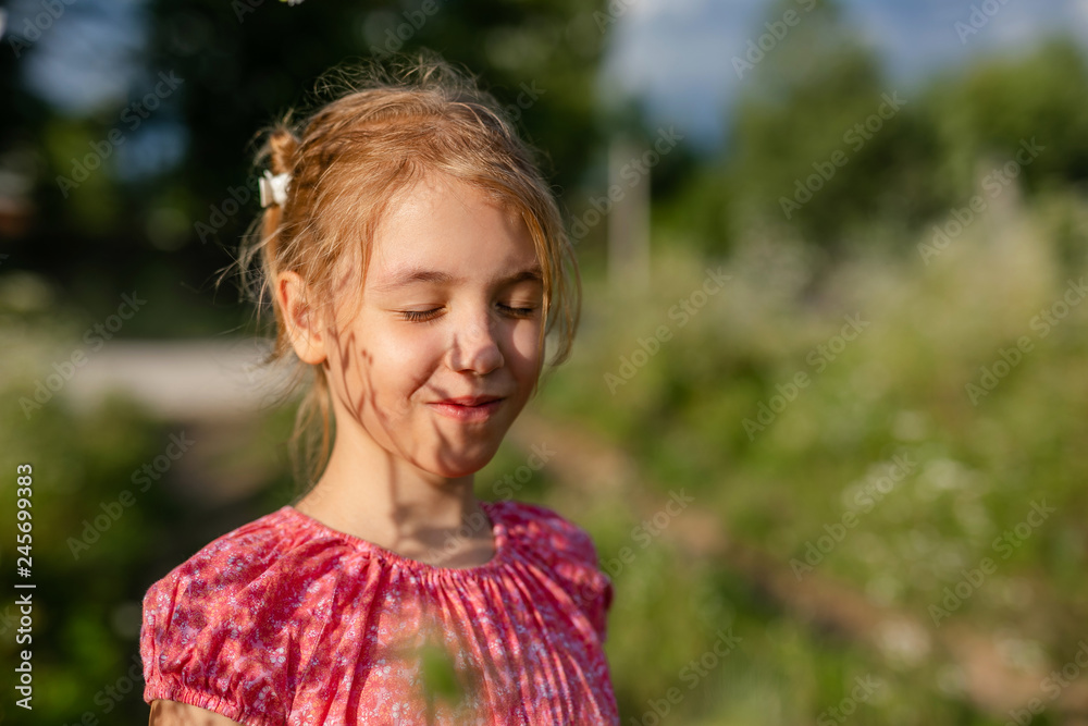 Cute blonde girl in straw hat and pink dress in the summer field at sunset Cute blonde girl in straw hat and pink dress in the summer field at sunset
