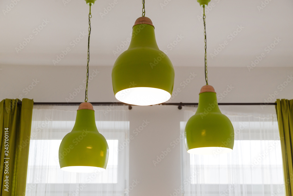 Obraz premium Three ceiling green lamps in white interior
