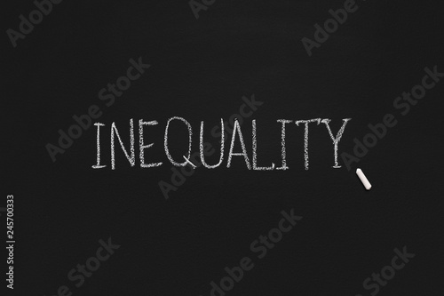 Word Inequality written on black board, panorama