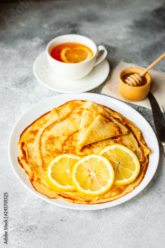 Food, dessert, pastries, pancake, pie. Tasty beautiful pancakes with banana and honey on a concrete background
