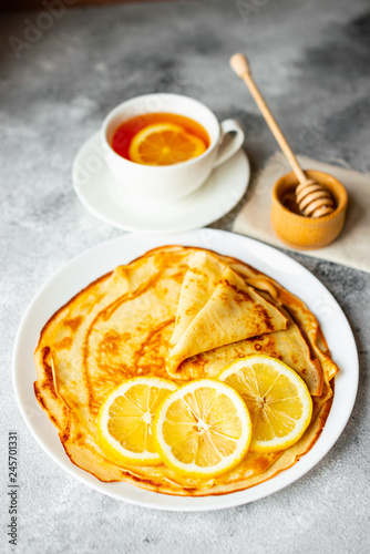 Food, dessert, pastries, pancake, pie. Tasty beautiful pancakes with banana and honey on a concrete background