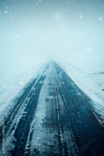 Empty black asphalt road in the snowy winter mountain landscape with heavy white fog background leading to nothing. Harz Mountains National Park in Germany  © Ricardo