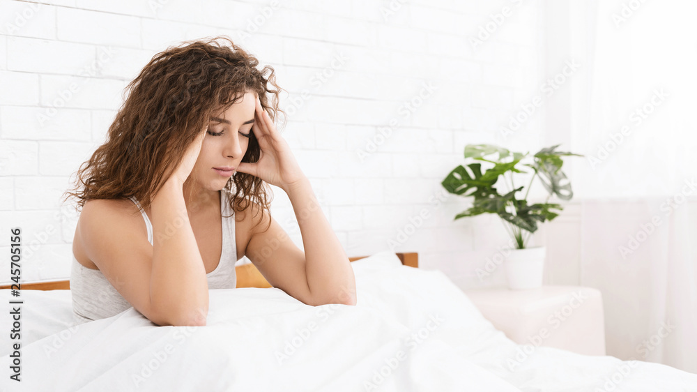 Frustrated young man touching his head and keeping eyes closed Frustrated young man touching his head and keeping eyes closed