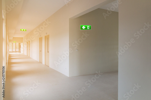 green emergency exit sign to install in new hospital building construction showing the way to escape