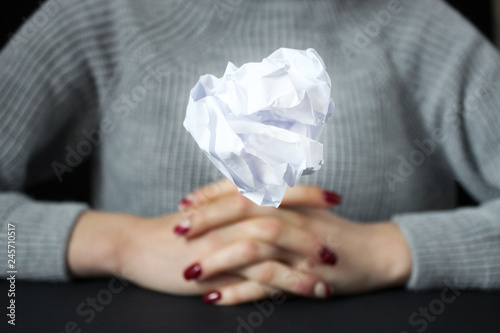 No idea and fail concept. Crumpled paper in the form of balls hangs up hand,  as metaphor for inability to express or creativity crisis.  it does not work out, a lot of stress and anxiety.