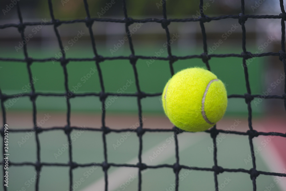 Close up tennis ball hitting to the net on court background with copy space