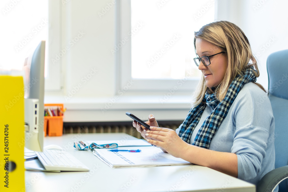 Female child therapist in an office during a phone call, using online calendar to schedule patients appointments. Calendar Planner Organization Management Concept.