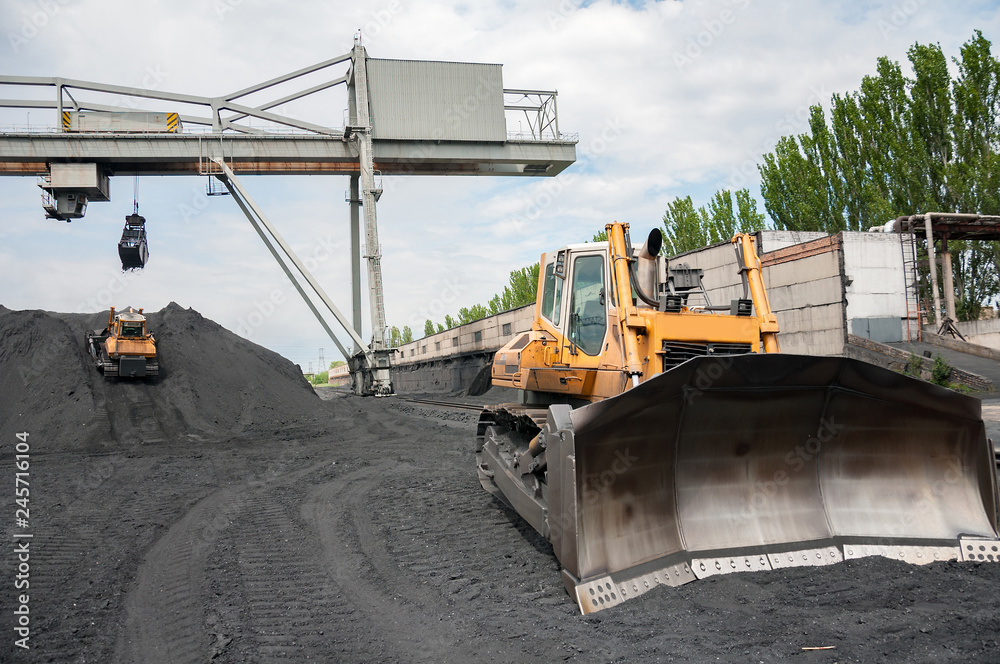 caterpillar tractor and travelling crane load black coal on supply field of thermoelectric power station caterpillar tractor and travelling crane load black coal on supply field of thermoelectric power station