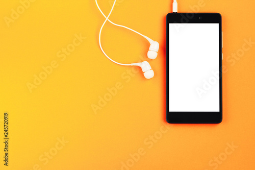 Wallpaper Mural Smartphone and headphones on an orange background. Top view, space for text Torontodigital.ca