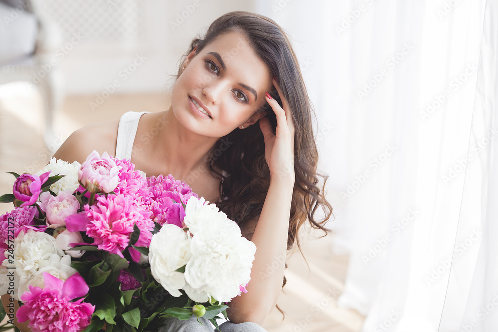 Beautiful woman holding flowers. Young lady with peony Beautiful woman holding flowers. Young lady with peony