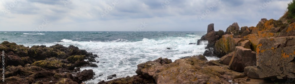 Sea waves breaks on rocks landscape. Waves crash and splash on rough shores. Panoramic shot. Sea waves breaks on rocks landscape. Waves crash and splash on rough shores. Panoramic shot.