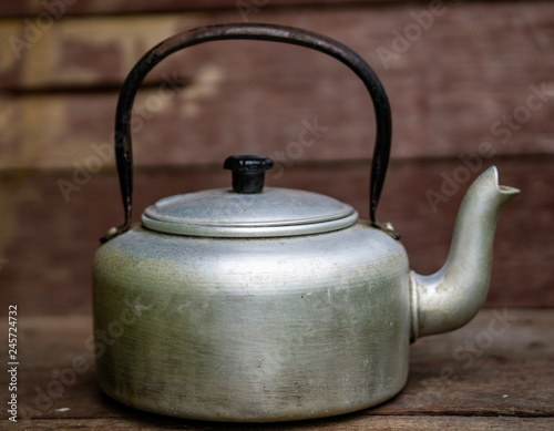 silver teapot or kettle isolated on wooden background