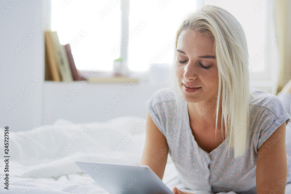 Girl holding digital tablet with blank screen and smiling at camera in bedroom Girl holding digital tablet with blank screen and smiling at camera in bedroom