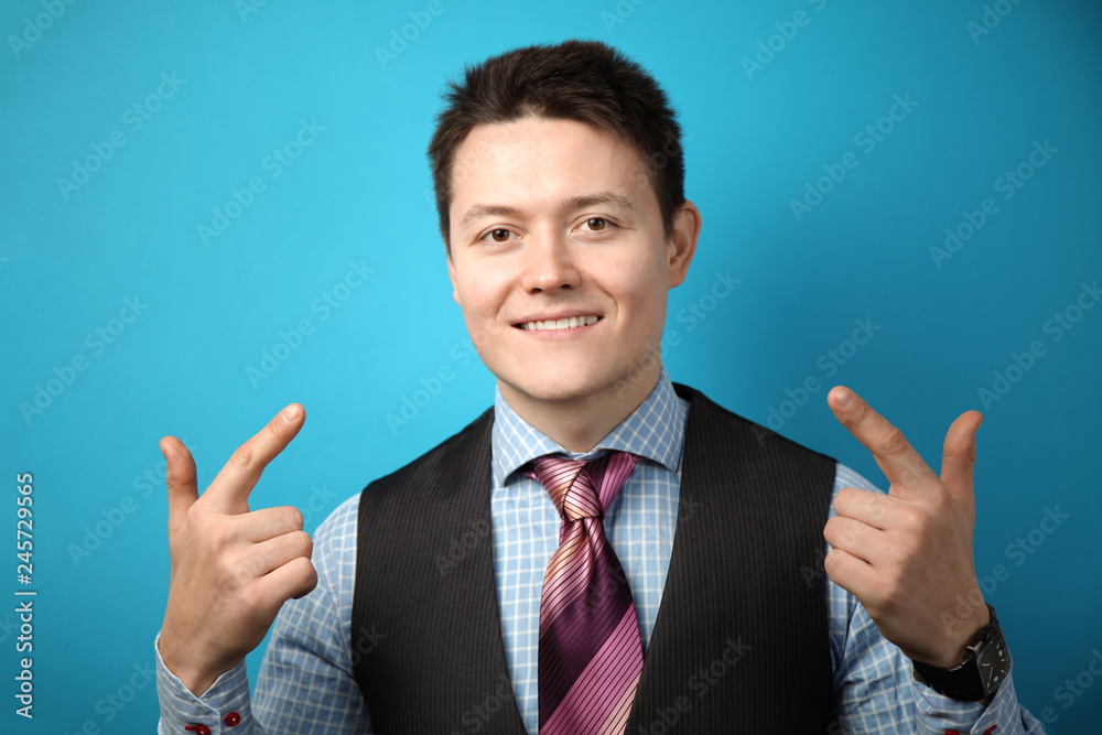 Adult businessman in suit on blue background points his finger at himself, smiling. Adult businessman in suit on blue background points his finger at himself, smiling.