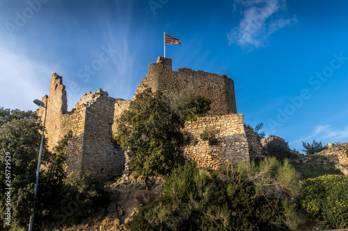 View of Palafolls castle medieval ruined stronghold between Girona and Barcelona on the Costa Brava with the Catalan flag proudly flying over the Romanesque church photo