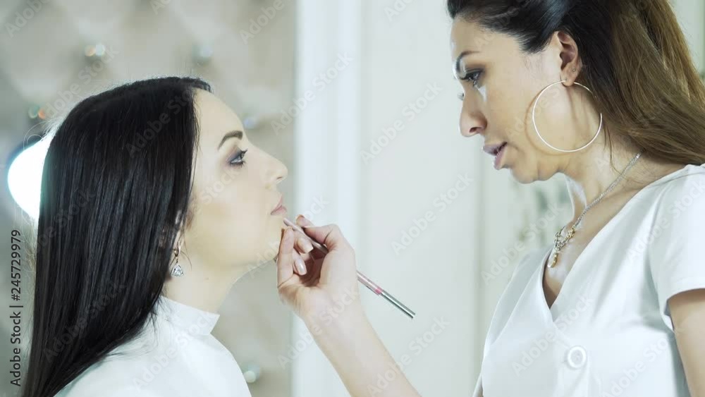 beautician in the beauty salon prepares lips for permanent makeup. Makeup in a beauty salon beautician in the beauty salon prepares lips for permanent makeup. Makeup in a beauty salon
