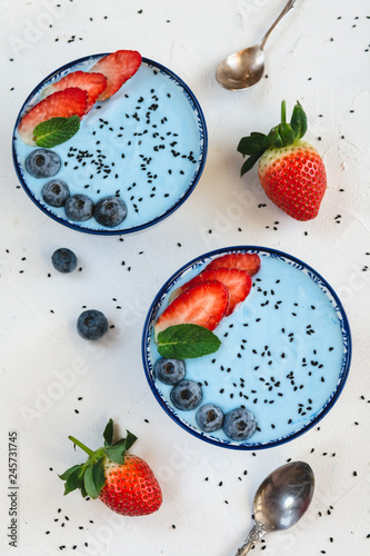Fototapeta Naklejka Na Ścianę i Meble -  Blue yogurt smoothie made with blue spirulina powder, strawberries and blueberries.
