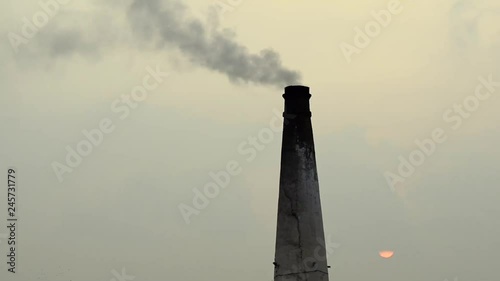 Smoke coming out of an industrial chimney during sunset