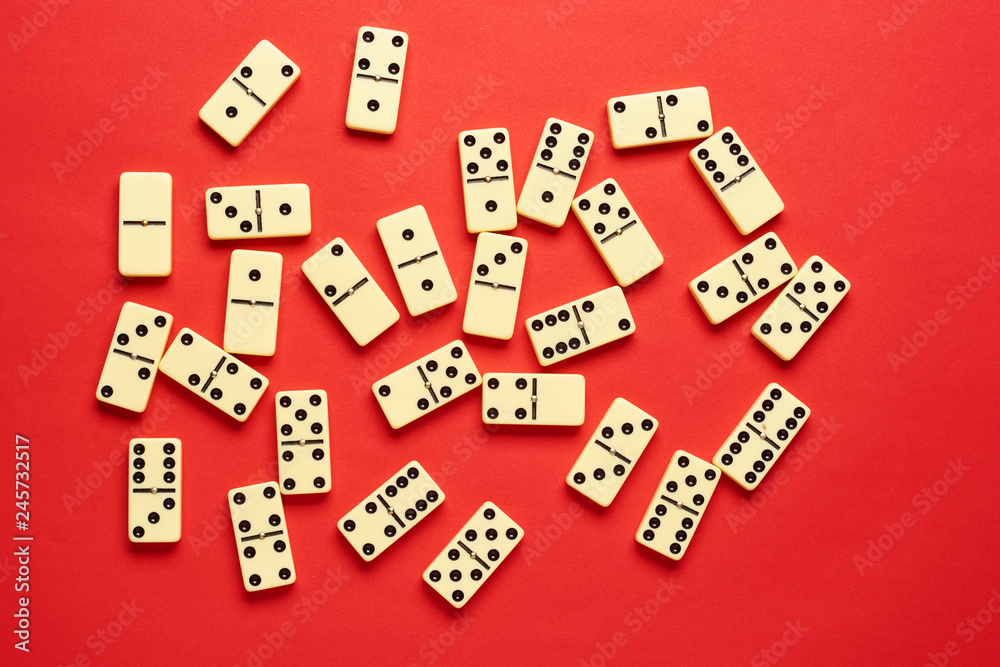 Flat lay concept. Board games publications. domino pieces on the red background with copy space. Flat lay concept. Board games publications. domino pieces on the red background with copy space.