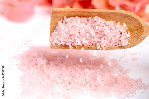 Pink sea salt dripping from a wooden spoon. photo