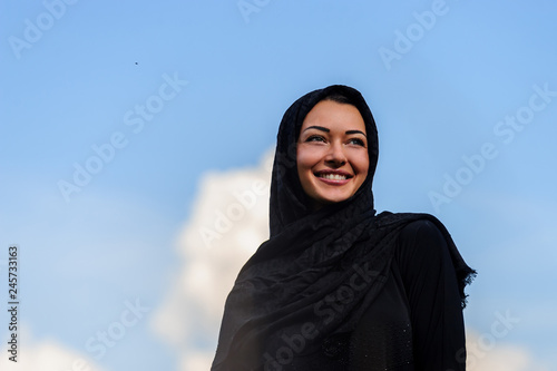 Beautiful middle eastern woman filling joy in the cloudy sky packground.