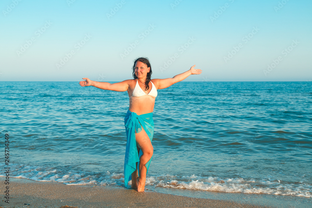 Young woman on the sea in a white swimsuit and blue pareo. Young woman on the sea in a white swimsuit and blue pareo.