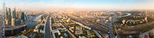 panorama high-rise buildings and transport of metropolis, traffic and blurry lights of cars on multi-lane highways and road junction at sunset in Moscow.