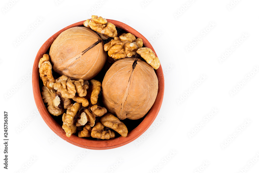 walnut kernels isolated on white background, in ceramic pot walnut kernels isolated on white background, in ceramic pot