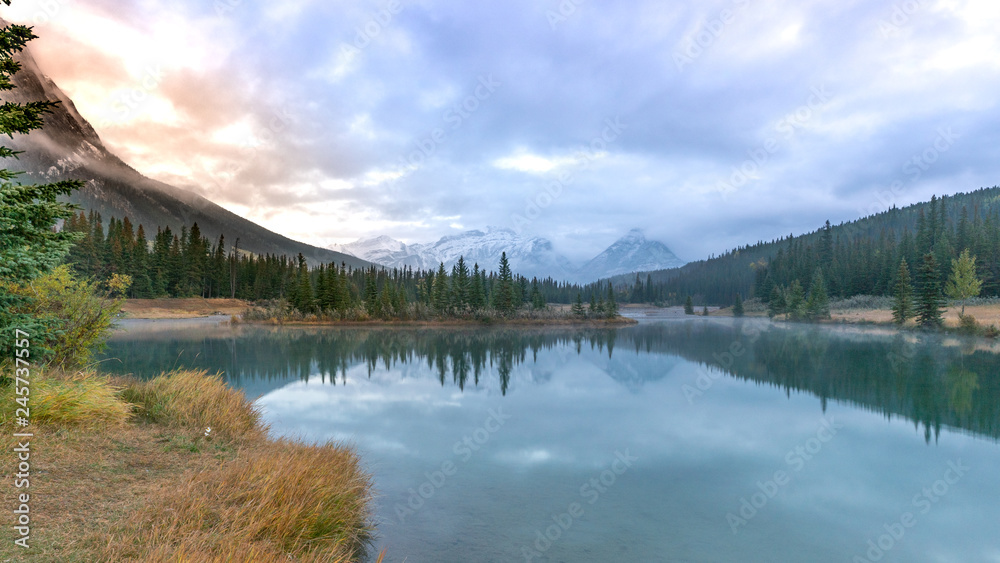 Smooth water reflection of Cascade pond in the morning at Banff National par