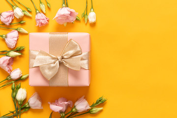 Happy Mother's Day, Women's Day, Valentine's Day or Birthday Yellow and Pastel Pink Colored Background. Flat lay greeting card with beautiful gift box and pink lisianthus flowers.