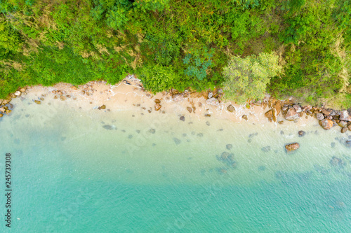 Aerial top view of ocean waves  beach and rocky coastline and beautiful forest. Beautiful nature background..