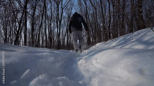 Man make a pace over camera, in the sky Man walks in the snow, rear view, Shoe trail close-up. bottom view photo