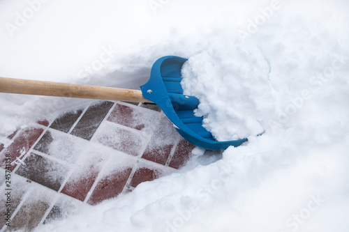 Cleaning snow with shovel in winter day