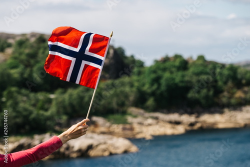 Tourist with norwegian flag on sea coast photo