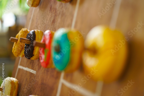 assortment of colorful fresh donuts on a wooden Board for the holiday