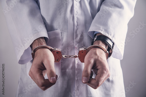 Doctor with handcuffs. Medical crime photo