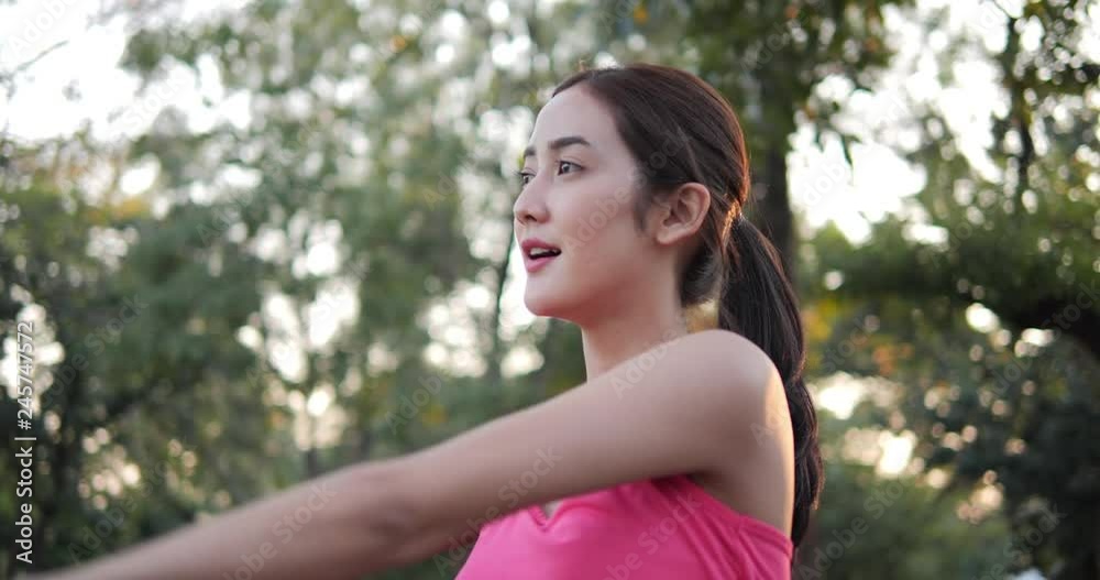 Young asian woman worm-up before exercise at park. People with healthcare, sport and exercise concept. Slow motion shot. Young asian woman worm-up before exercise at park. People with healthcare, sport and exercise concept. Slow motion shot.