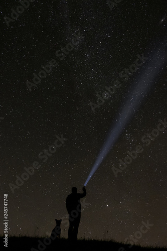 man looking at the stars with his dog