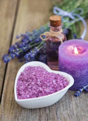 Heart-shaped bowl with sea salt and fresh lavender flowers on a old wooden table