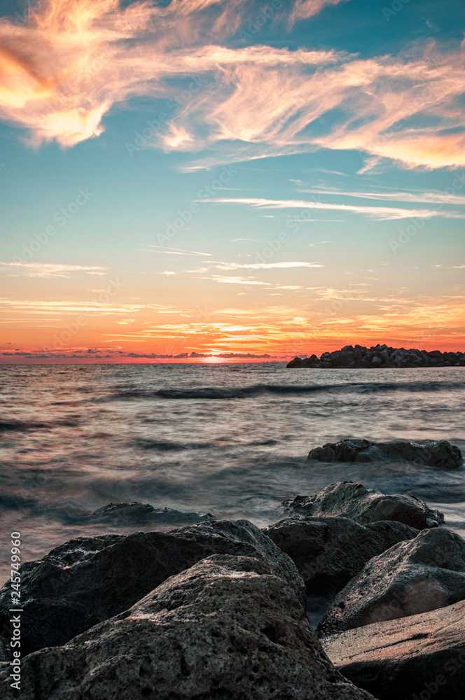 sunset at sea with rocks in the foreground sunset at sea with rocks in the foreground