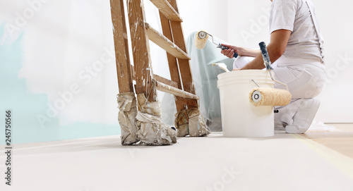 painter man at work with a roller, bucket and scale, from below view, copy space template photo