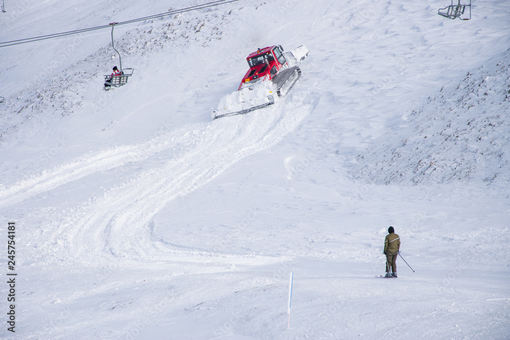 Snow groomer machine prepares the snow for recreational activities in a slope at Velouchi mountain in Karpenissi, Greece